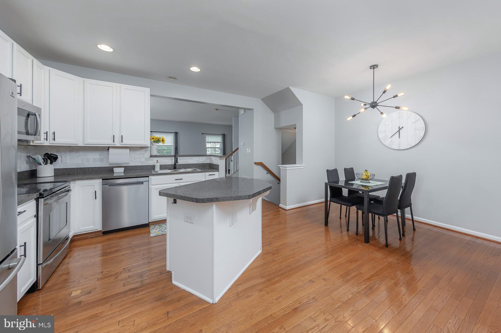 372 Concetta Drive Mount Royal, NJ 08061 - Photo 7 of 25 a kitchen with stainless steel appliances granite countertop a stove top oven a sink dishwasher a dining table and chairs with wooden floor