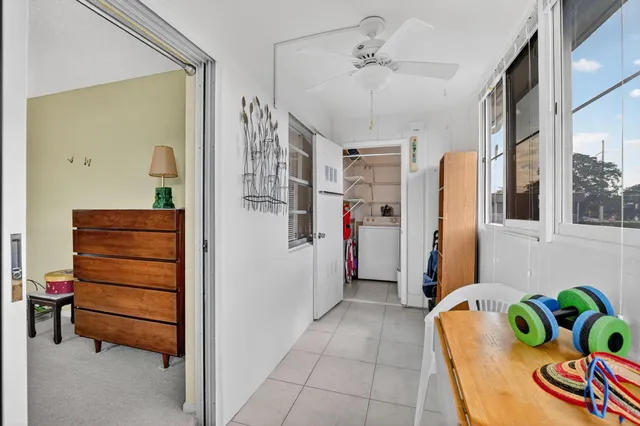a room with a black white checkered floor with couches and a coffee table
