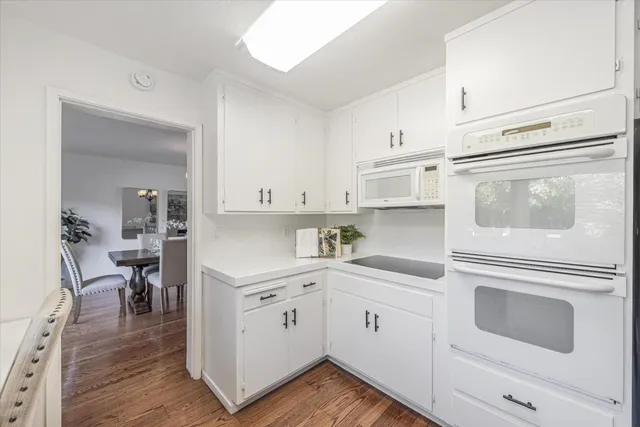a kitchen with cabinets stainless steel appliances and wooden floor