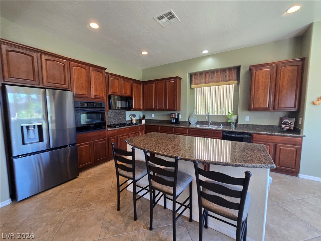 2567 Dirleton Place Henderson, NV 89044 - Photo 10 of 67 A gourmet kitchen boasts granite counters, ample cabinetry, and sleek stainless steel appliances.