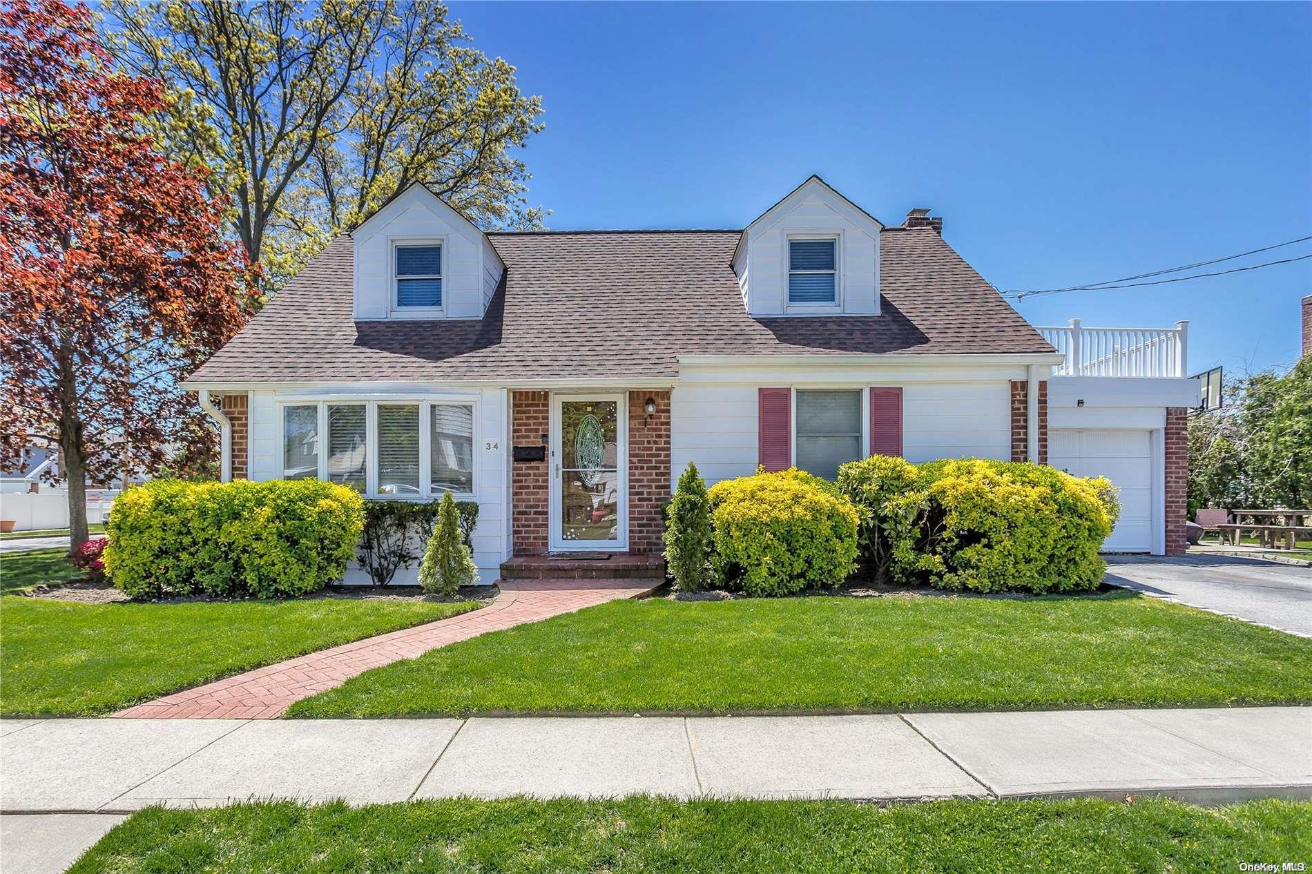 a front view of a house with a garden and plants