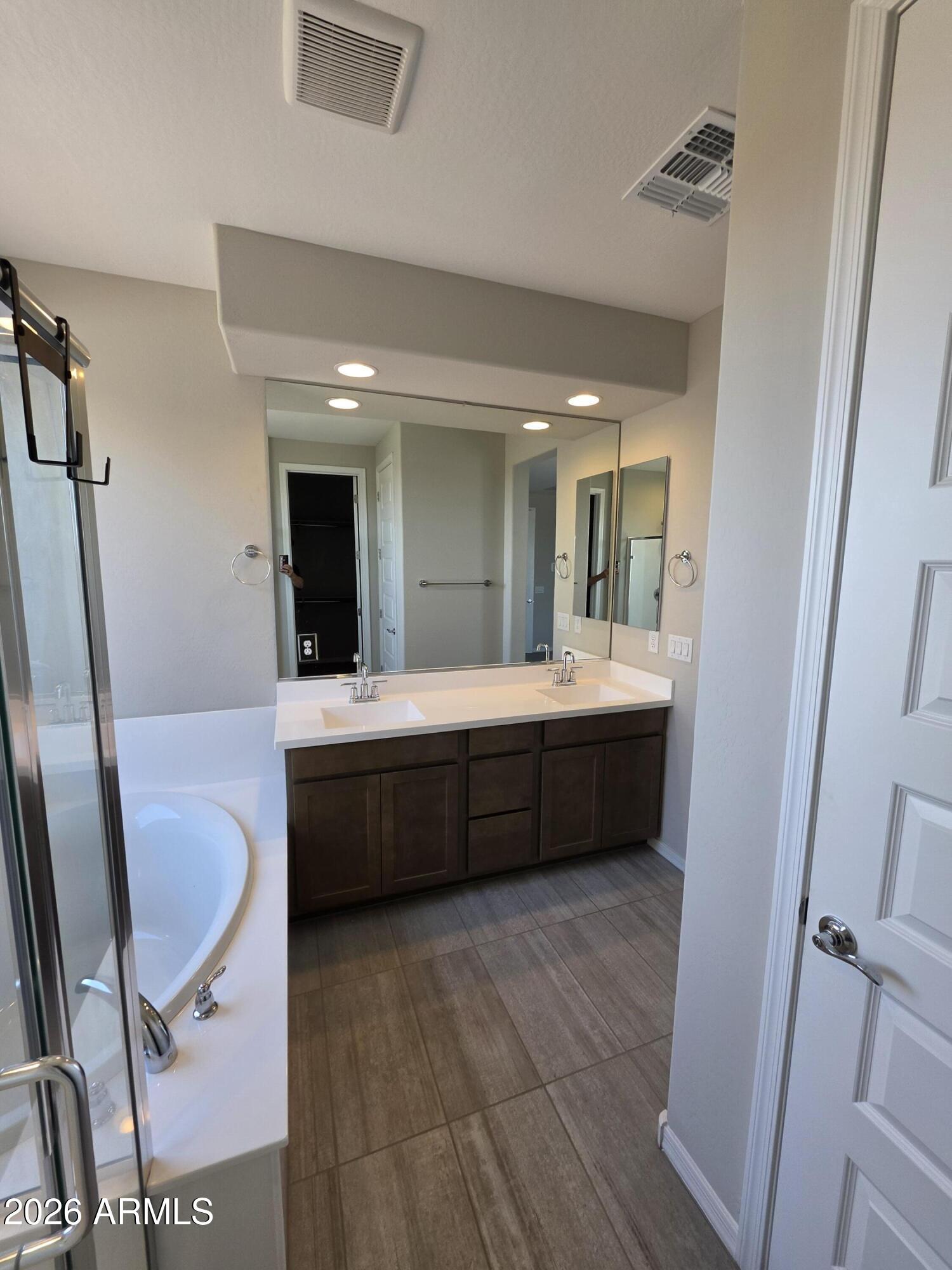 7128 West Coles Road Laveen, AZ 85339 - Photo 18 of 38 a bathroom with a double vanity sink a mirror and a bathtub
