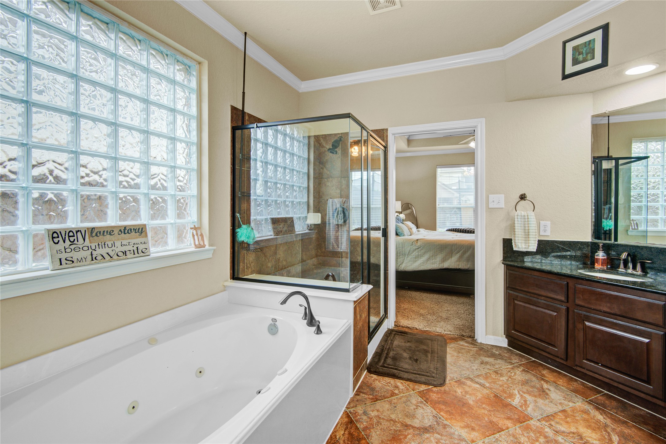 6007 Valhalla Drive Spring, TX 77379 - Photo 21 of 37 Natural light pours into the luxurious primary bath highlighting the soaking tub, glass block window, and elegant finishes.