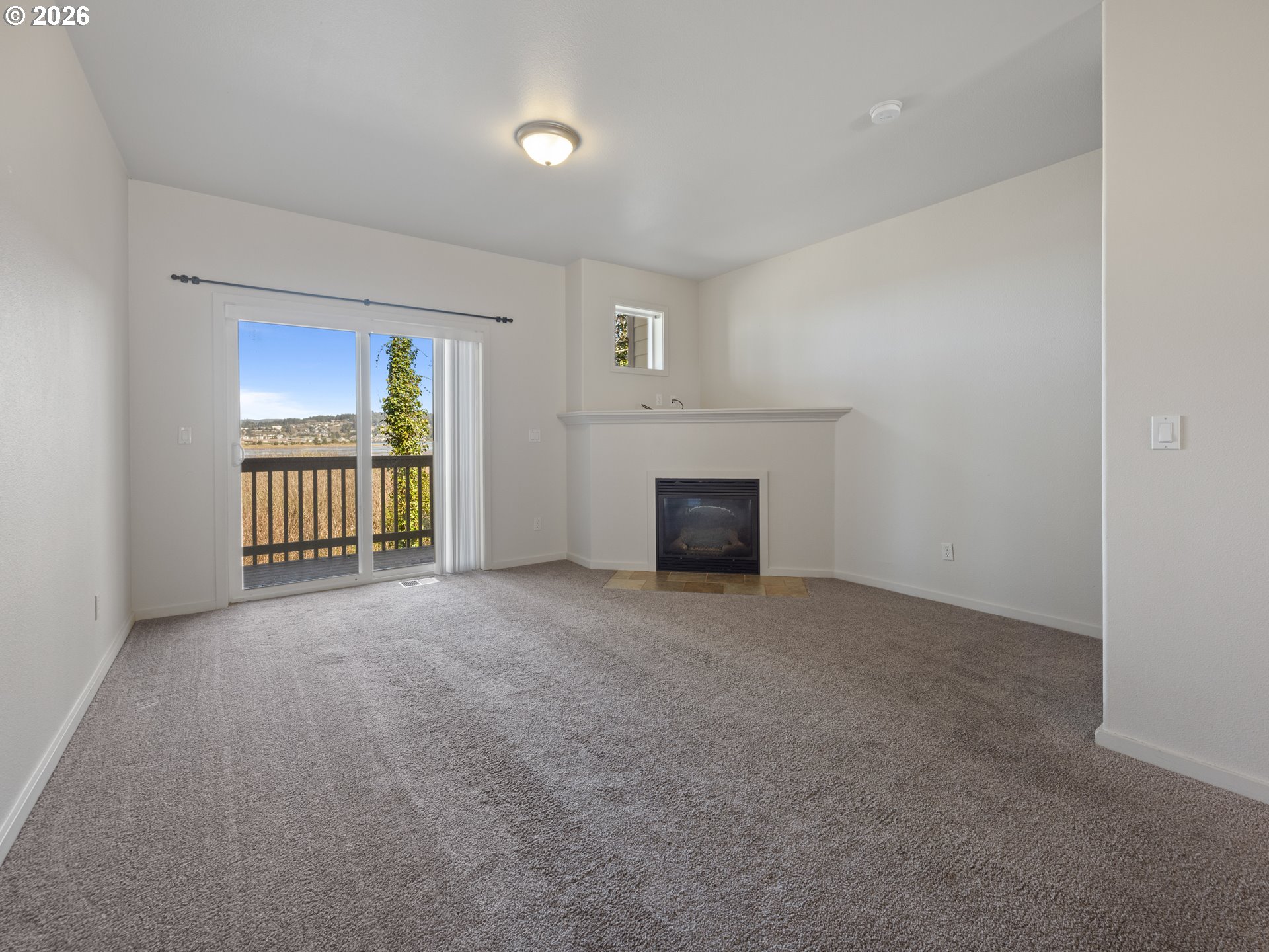 475 Southeast 35th Street, Unit C15 Newport, OR 97366 - Photo 17 of 41 a view of an empty room with a fireplace and a window