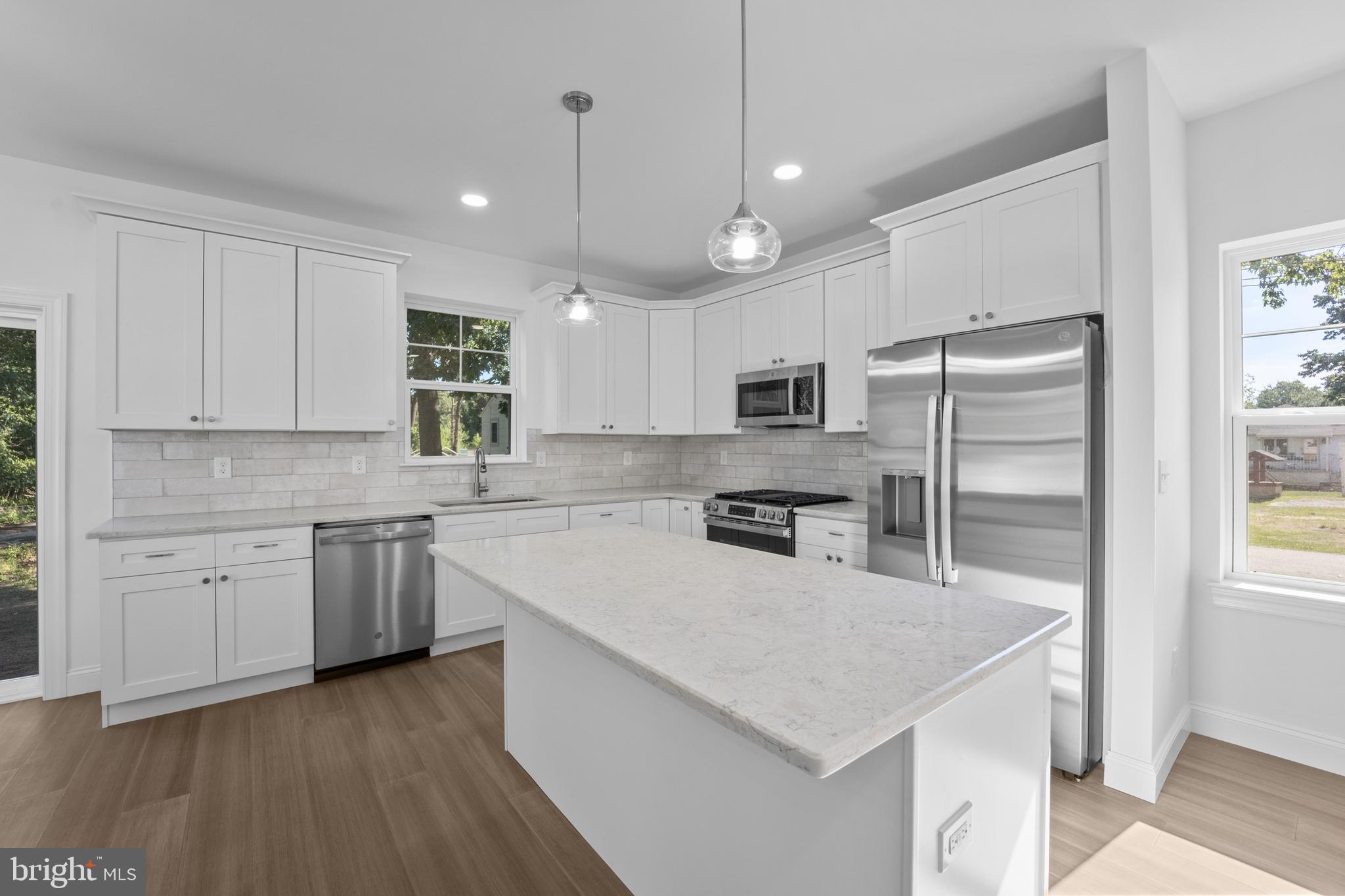 492 Ellis Avenue Lawnside, NJ 08045 - Photo 10 of 33 a kitchen with a refrigerator a sink and wooden floor