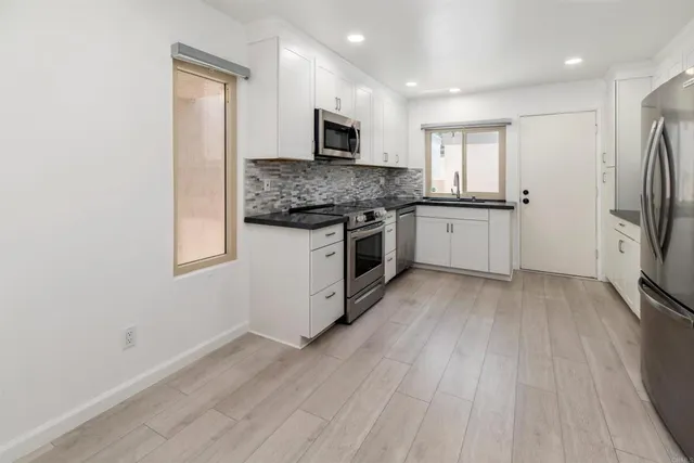 a kitchen with stainless steel appliances granite countertop a stove a sink and a refrigerator