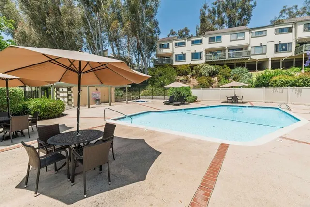 a view of a patio with a table and chairs under an umbrella