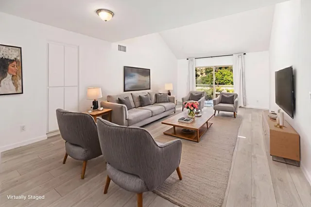 a living room with furniture flat screen tv and a window
