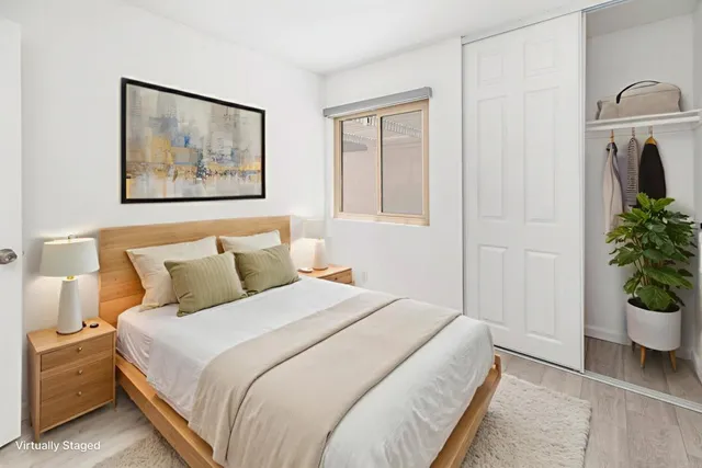 a bedroom with a bed and a painting on the wall