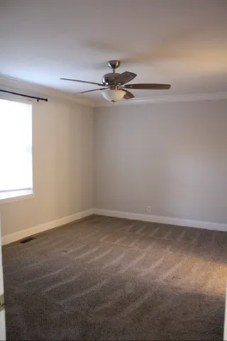 an empty room with a windows and ceiling fan