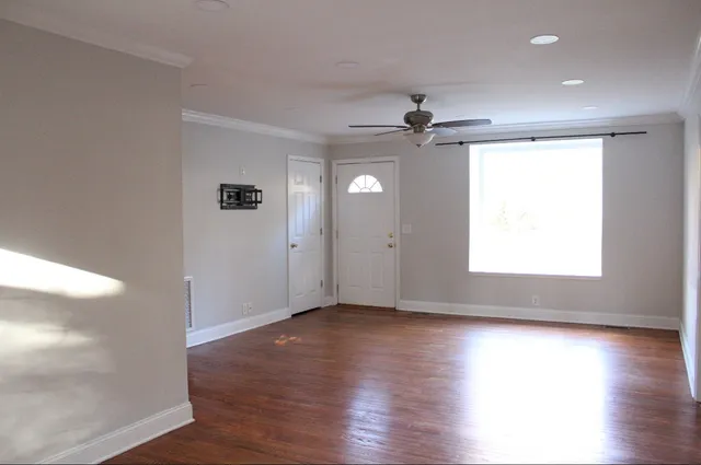 an empty room with wooden floor and windows