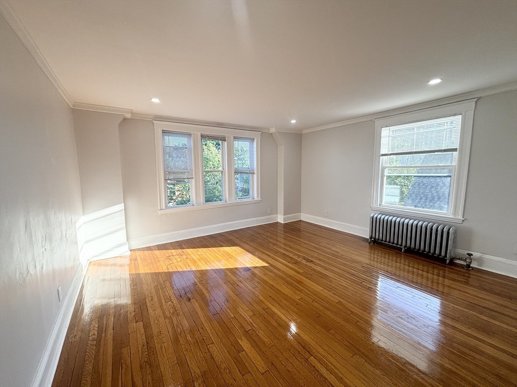 36 Spring Street, Unit 11 Malden, MA 02148 - Photo 6 of 12 an empty room with wooden floor and windows