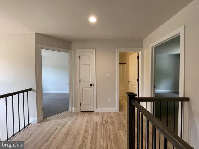 a view of a hallway with wooden floor and entryway