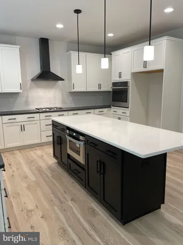 a kitchen with stainless steel appliances granite countertop a sink a stove and a wooden floors