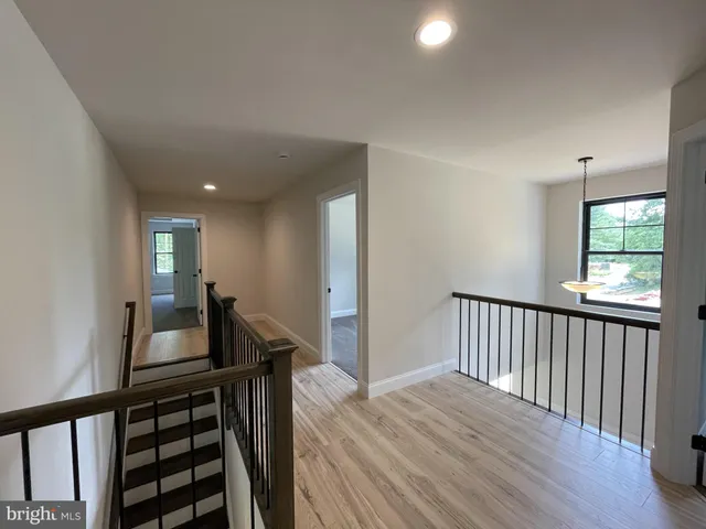 a view of a hallway with wooden floor and stairs