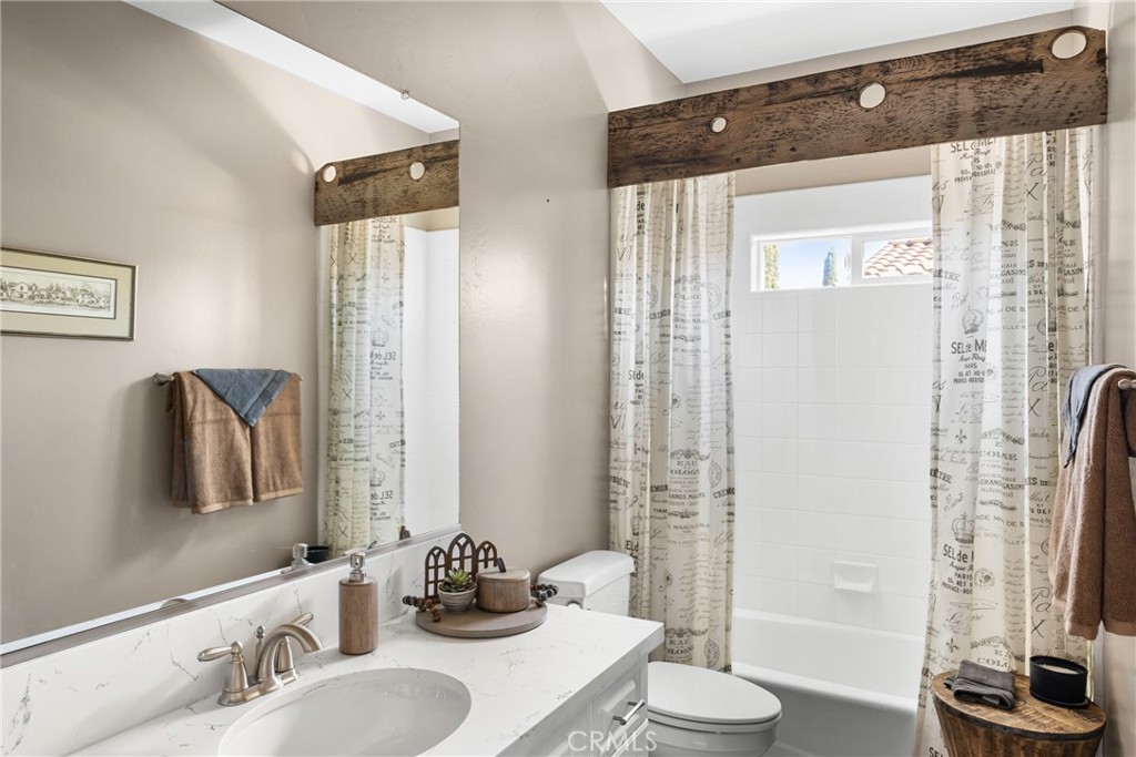 585 Valley Oak Road Solvang, CA 93463 - Photo 33 of 36 a bathroom with a granite countertop sink a toilet and a mirror