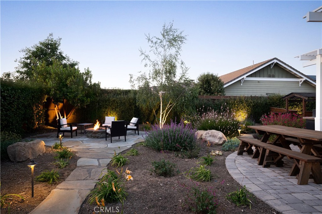 585 Valley Oak Road Solvang, CA 93463 - Photo 5 of 36 a view of a patio with table and chairs under an umbrella with a fire pit