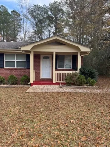 a front view of a house with yard and trees