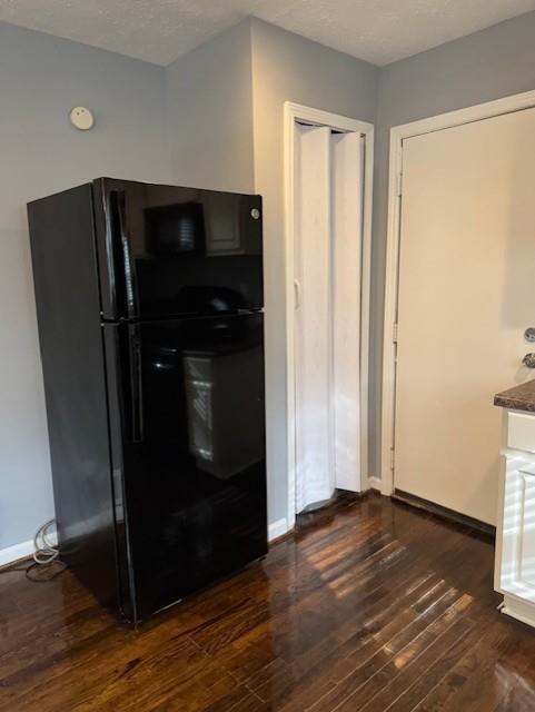 3741 Hopkins Road, Unit A Powder Springs, GA 30127 - Photo 11 of 25 a view of a refrigerator in kitchen and an empty room with wooden floor
