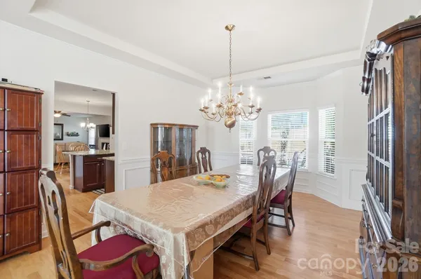 a view of a dining room with furniture a chandelier and wooden floor