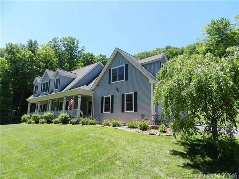 325 Colebrook Road Winchester, CT 06098 - Photo 1 of 1 a front view of a house with a yard table and chairs