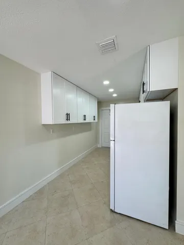 a view of a kitchen with a refrigerator and a sink