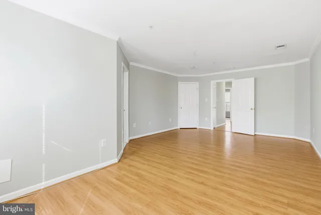 a view of empty room with wooden floor