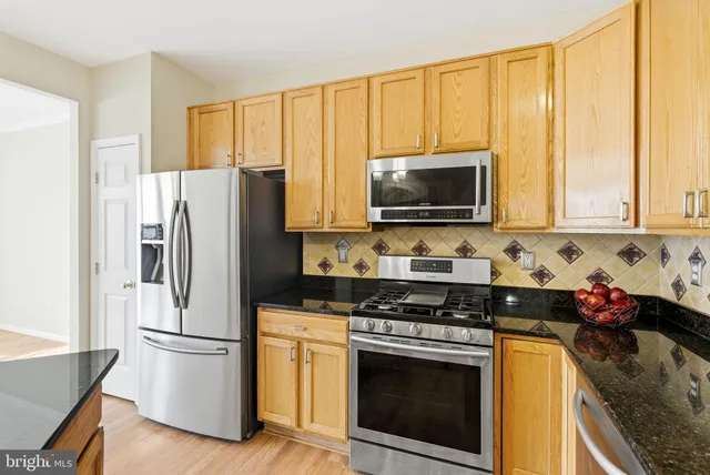 a kitchen with stainless steel appliances a stove a microwave and a refrigerator