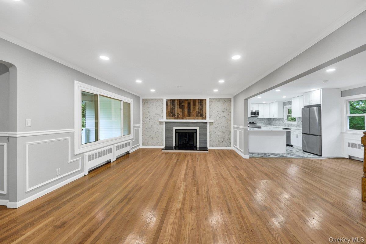 7 Rutledge Road Valhalla, NY 10595 - Photo 8 of 37 Open-concept living area featuring wood-finish flooring, recessed lighting, and a fireplace with a wood-plank accent wall