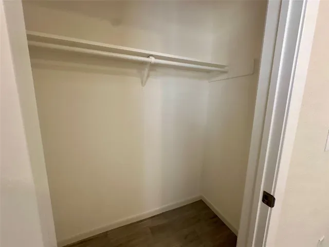 a small space with a hardwood floor and a window