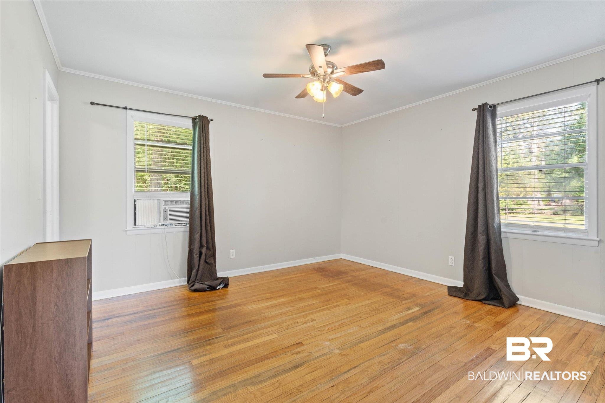 427 Upper Ferry Road Leroy, AL 36548 - Photo 10 of 37 Spare room featuring ceiling fan, light wood-style flooring, crown molding, baseboards, and cooling unit
