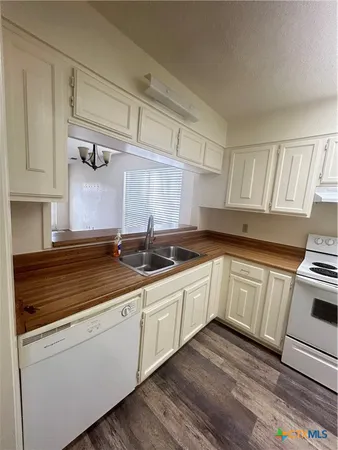 a kitchen with granite countertop white cabinets and white appliances