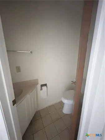 a bathroom with a granite countertop toilet and a sink