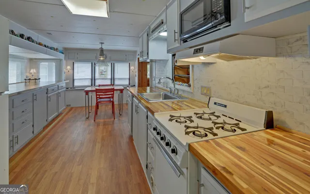 a kitchen with stainless steel appliances a sink stove and refrigerator