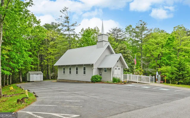 a view of house with swimming pool and sitting area