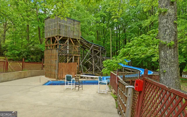 an aerial view of residential house with outdoor space and trees all around