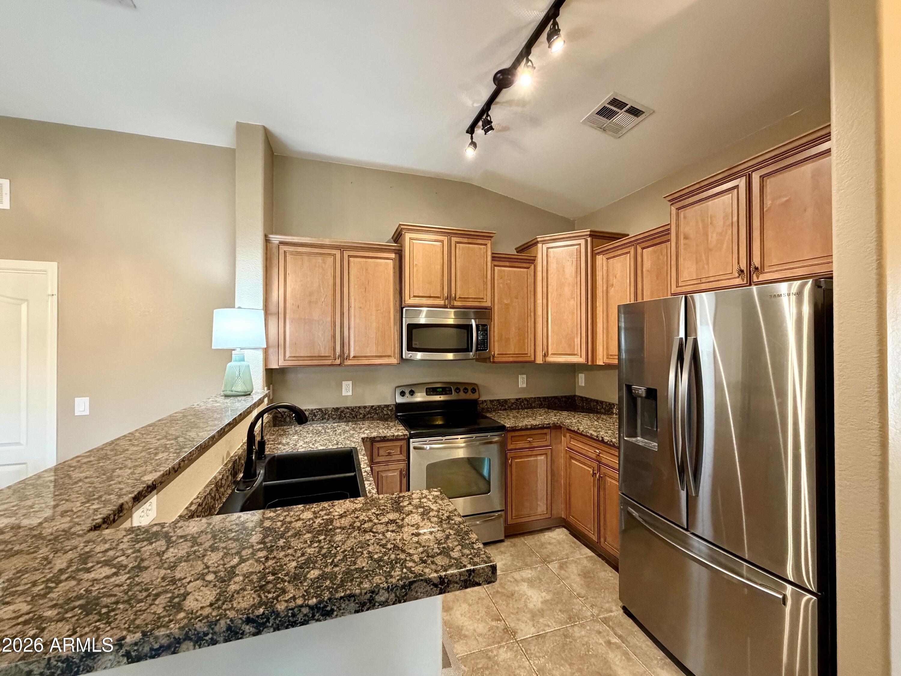 2725 East Mine Creek Road, Unit 2058 Phoenix, AZ 85024 - Photo 4 of 16 a kitchen with stainless steel appliances granite countertop a refrigerator sink stove microwave and cabinets