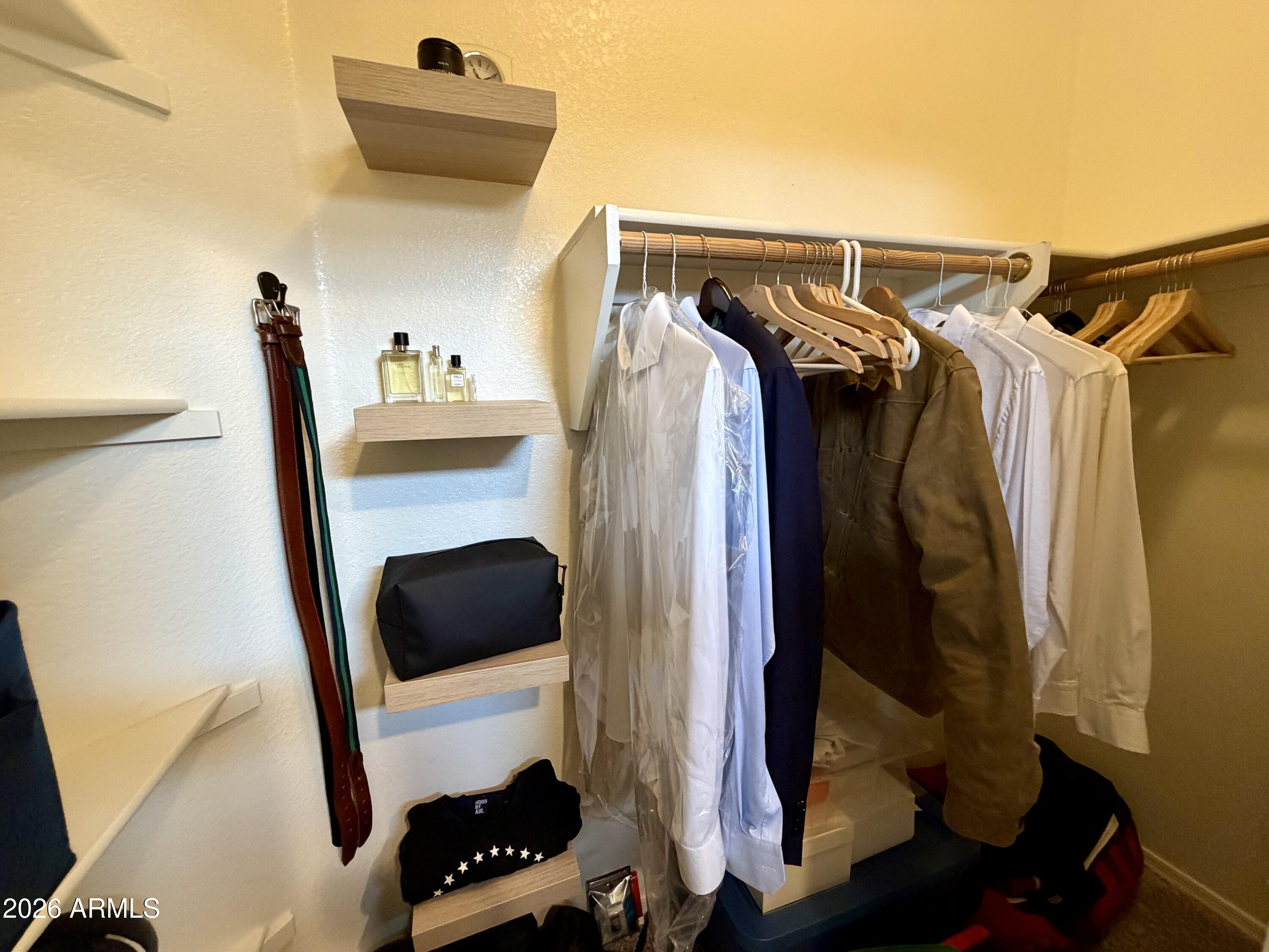 2725 East Mine Creek Road, Unit 2058 Phoenix, AZ 85024 - Photo 10 of 16 a view of walk in closet with clothes and shoes