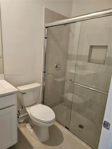 a white toilet sitting next to a shower