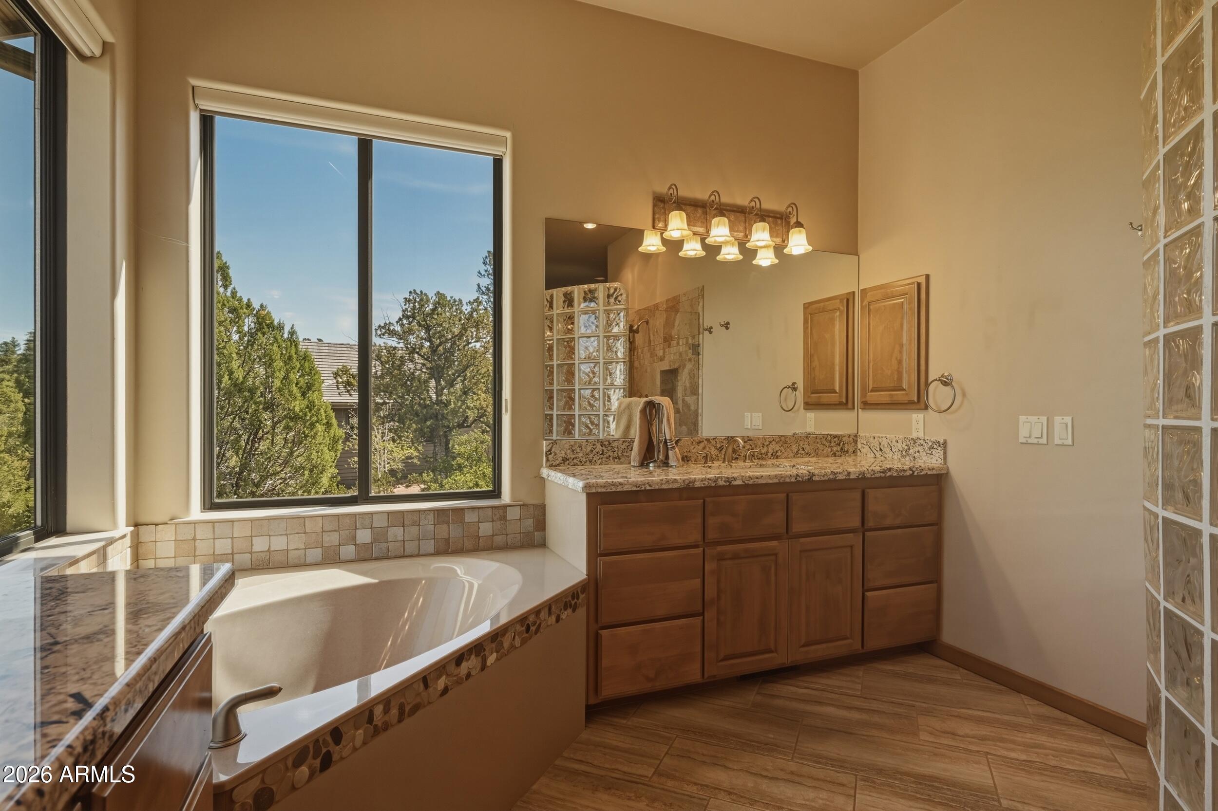 3101 East Mayfield Payson, AZ 85541 - Photo 31 of 71 a bathroom with a tub a double vanity sink and a large mirror