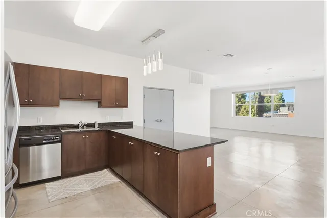 a kitchen with stainless steel appliances granite countertop a stove a sink and a refrigerator
