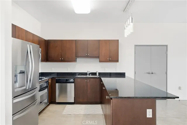 a kitchen with stainless steel appliances granite countertop a refrigerator and a stove