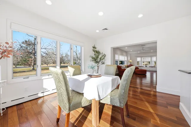 a view of a dining room with furniture large windows and wooden floor