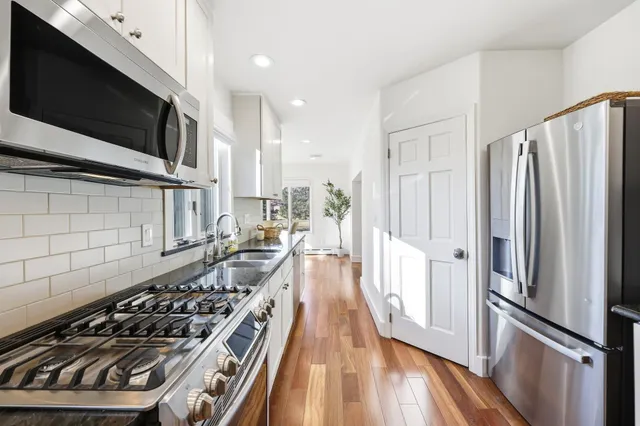 a kitchen with stainless steel appliances a stove a refrigerator and a microwave