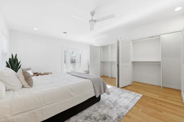 a bedroom with a large bed and ceiling fan