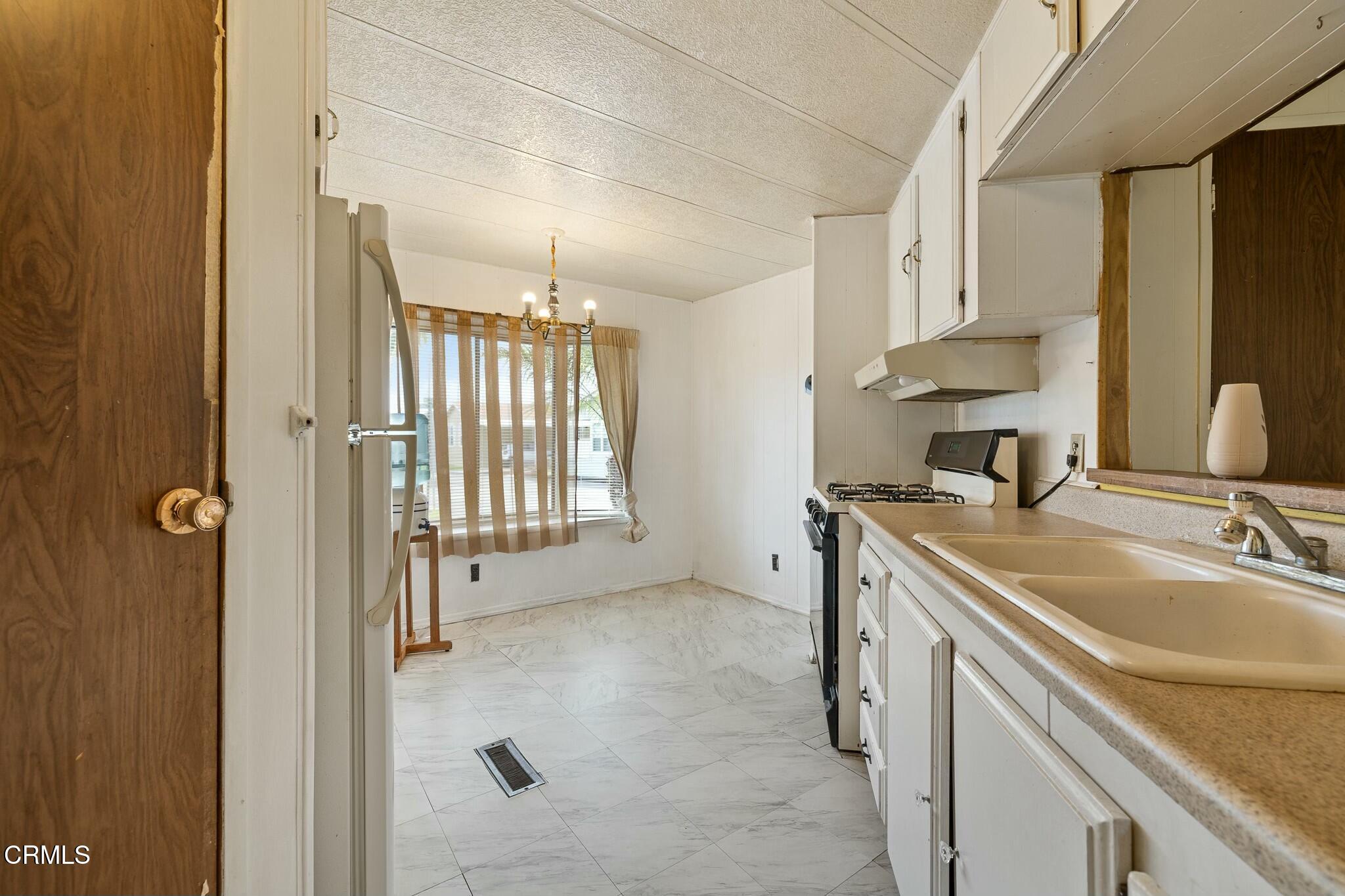 1853 Ives Avenue, Unit 51 Oxnard, CA 93033 - Photo 12 of 38 a bathroom with a granite countertop sink a mirror and a shower