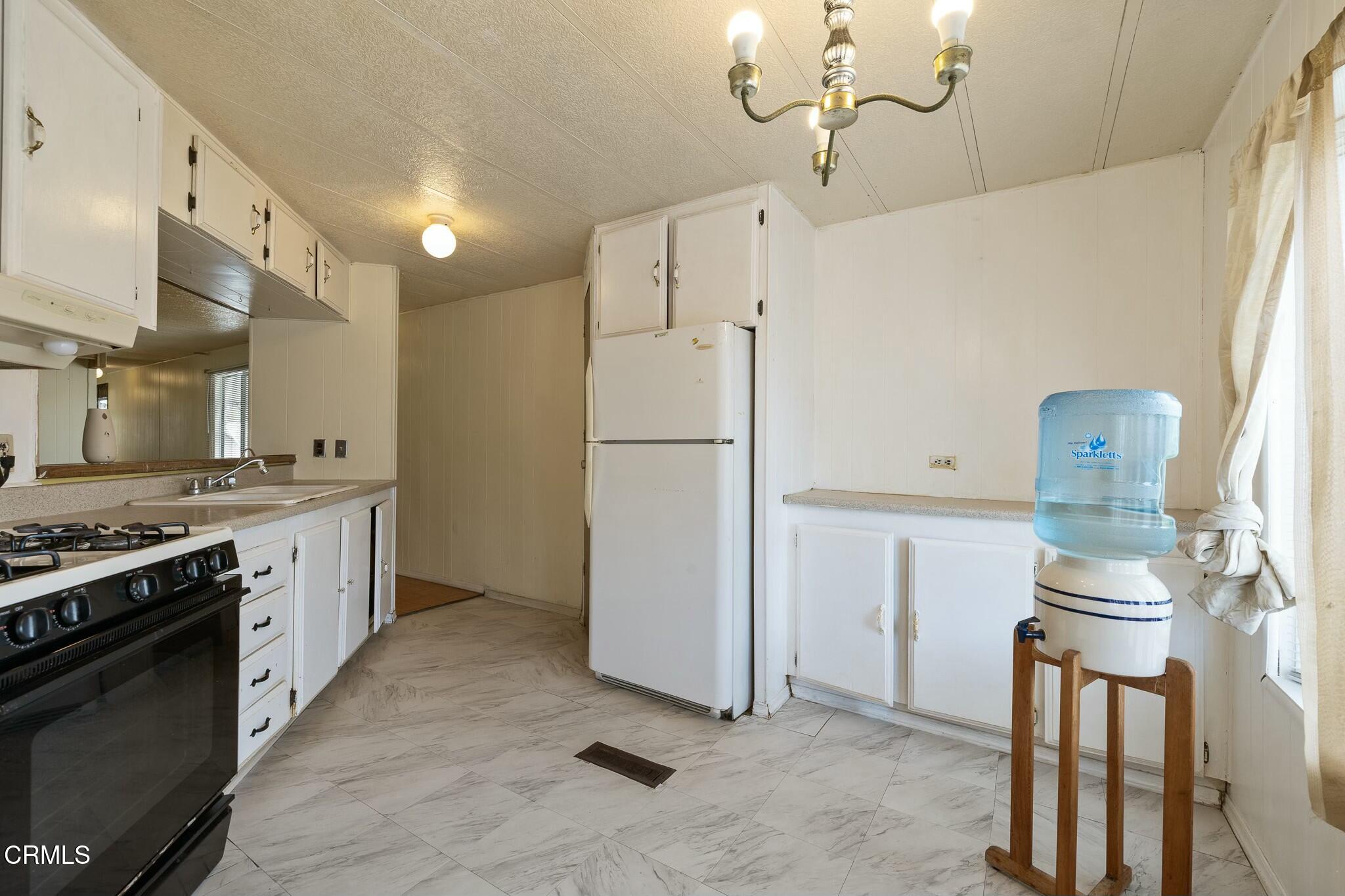 1853 Ives Avenue, Unit 51 Oxnard, CA 93033 - Photo 15 of 38 a kitchen with a refrigerator and a stove