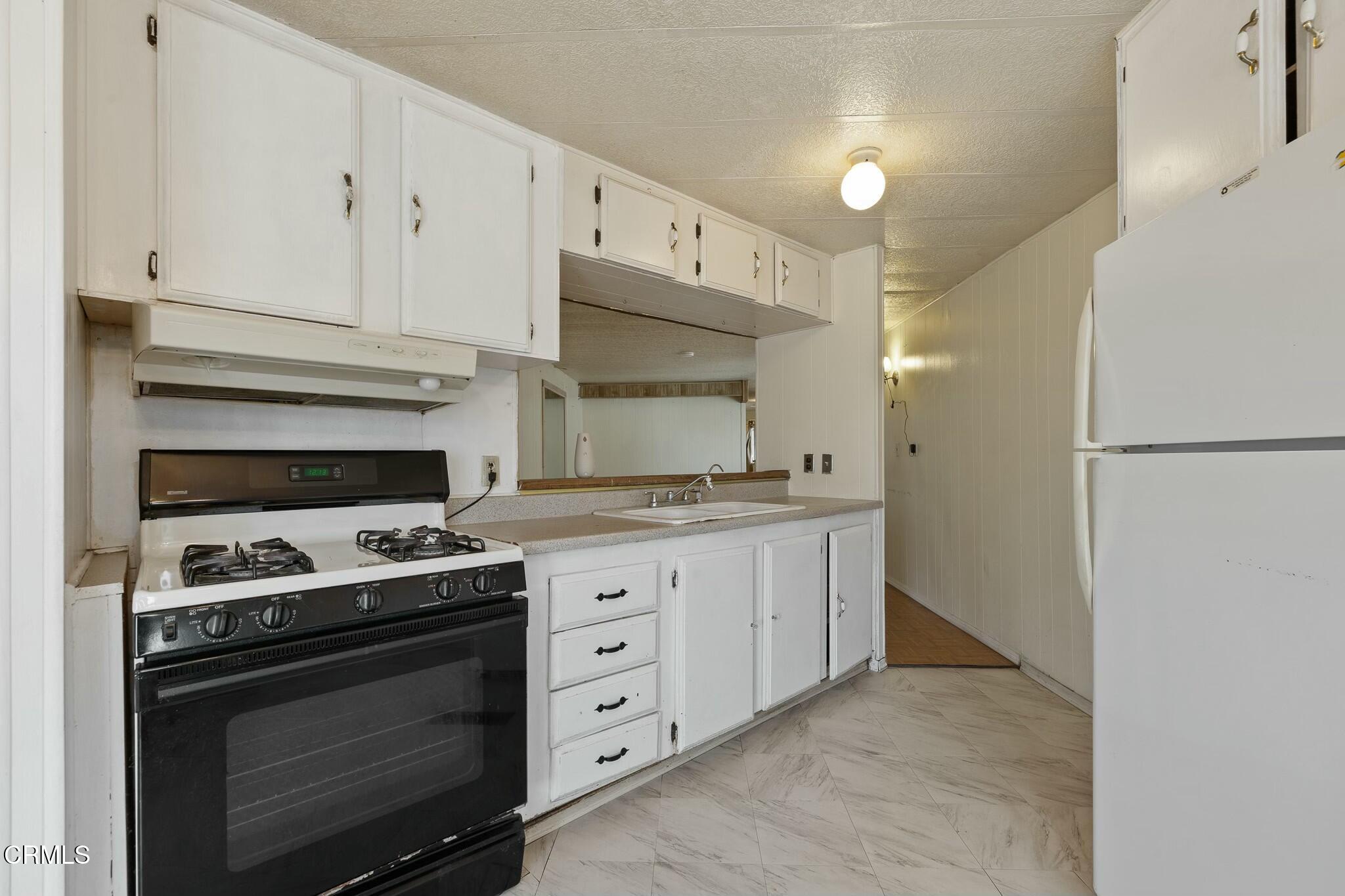 1853 Ives Avenue, Unit 51 Oxnard, CA 93033 - Photo 16 of 38 a kitchen with granite countertop cabinets and steel stainless steel appliances