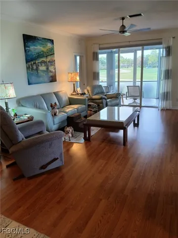 a living room with furniture and a wooden floor
