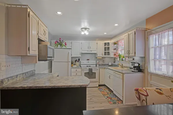 a kitchen with kitchen island granite countertop a sink appliances cabinets and furniture